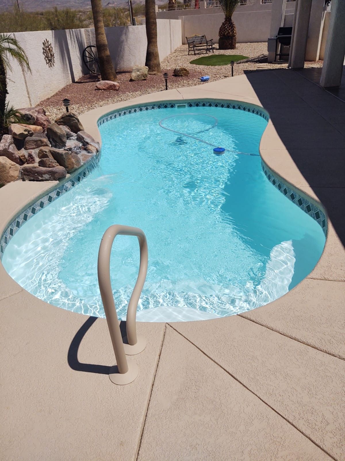 Backyard fiberglass pool with patio seating